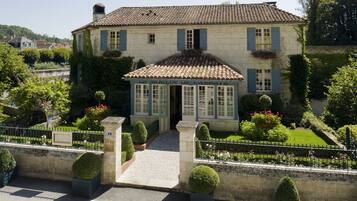 Un bâtiment à deux étages, doté d’un toit recouvert de tuiles, d’une entrée centrale avec une porte en verre et d’une enseigne au-dessus de la porte.