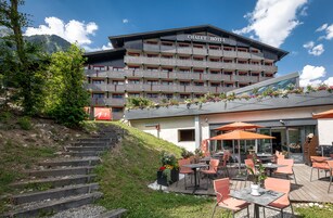 Um hotel com design moderno, área de estar ao ar livre e escadaria que leva à entrada.