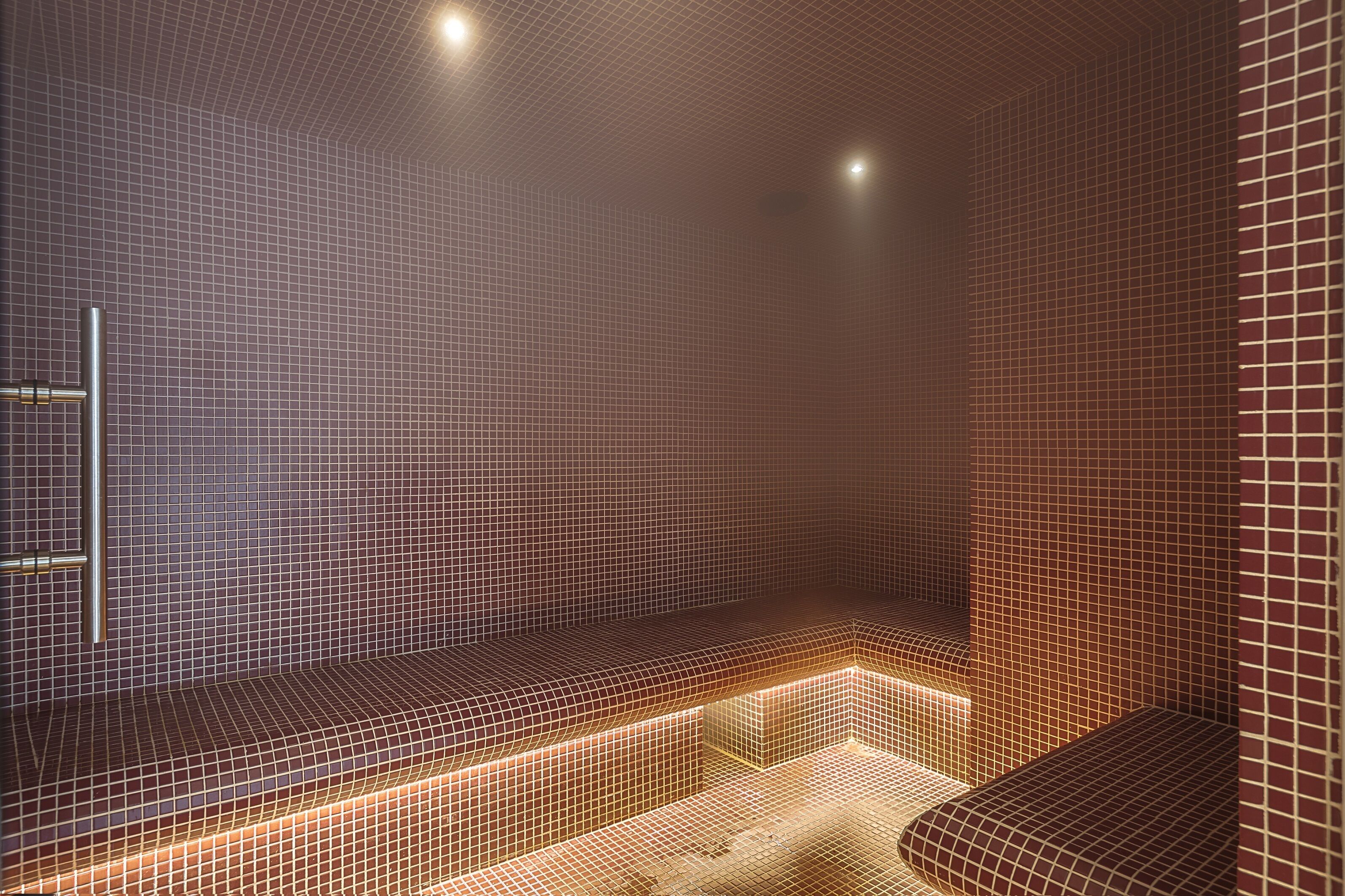 A modern spa with a tiled wall and bench seating.