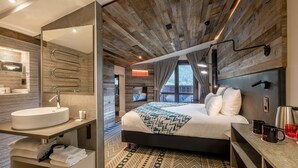 Una habitación de hotel moderna con una cama grande, un lavamanos integrado y un espejo.