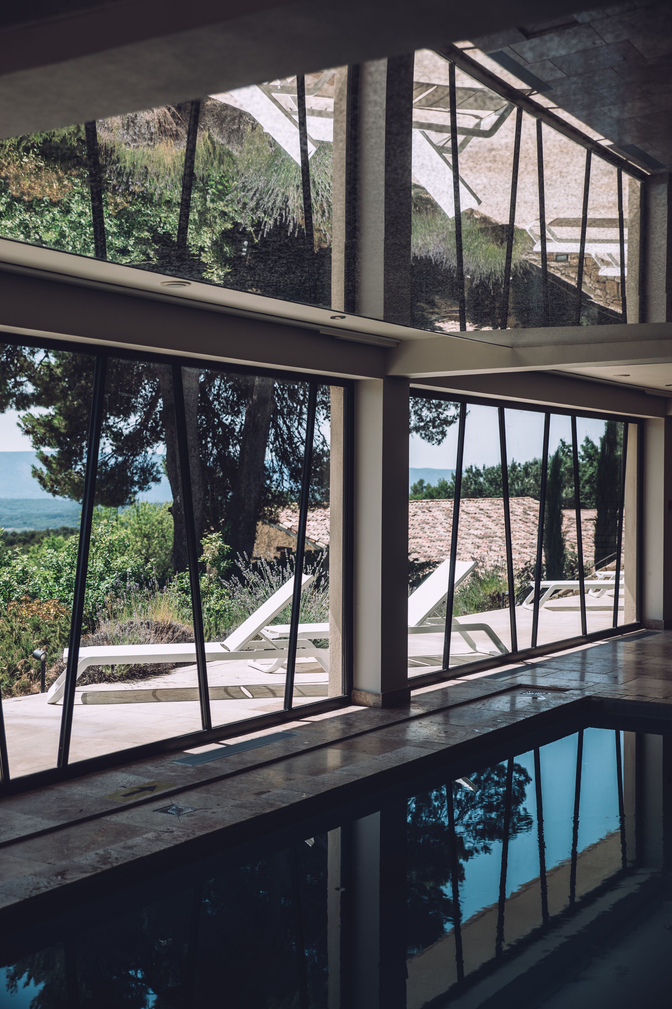 A pool area with a view of the sea and surrounding vegetation.