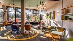 A modern interior with a circular seating area, a sofa, and a dining space with tables and chairs.