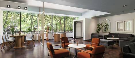 A modern interior with a dining area, seating, and large windows.