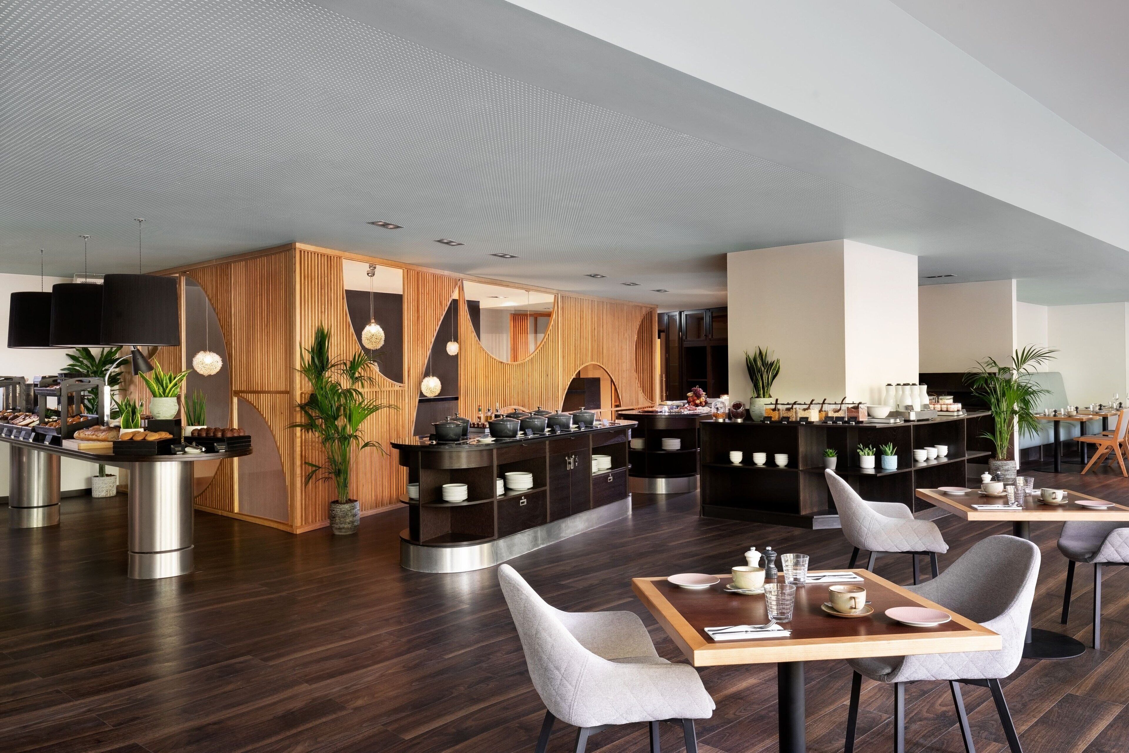 Un restaurant moderne avec des éléments décoratifs en bois, un revêtement de sol foncé et un mobilier contemporain.