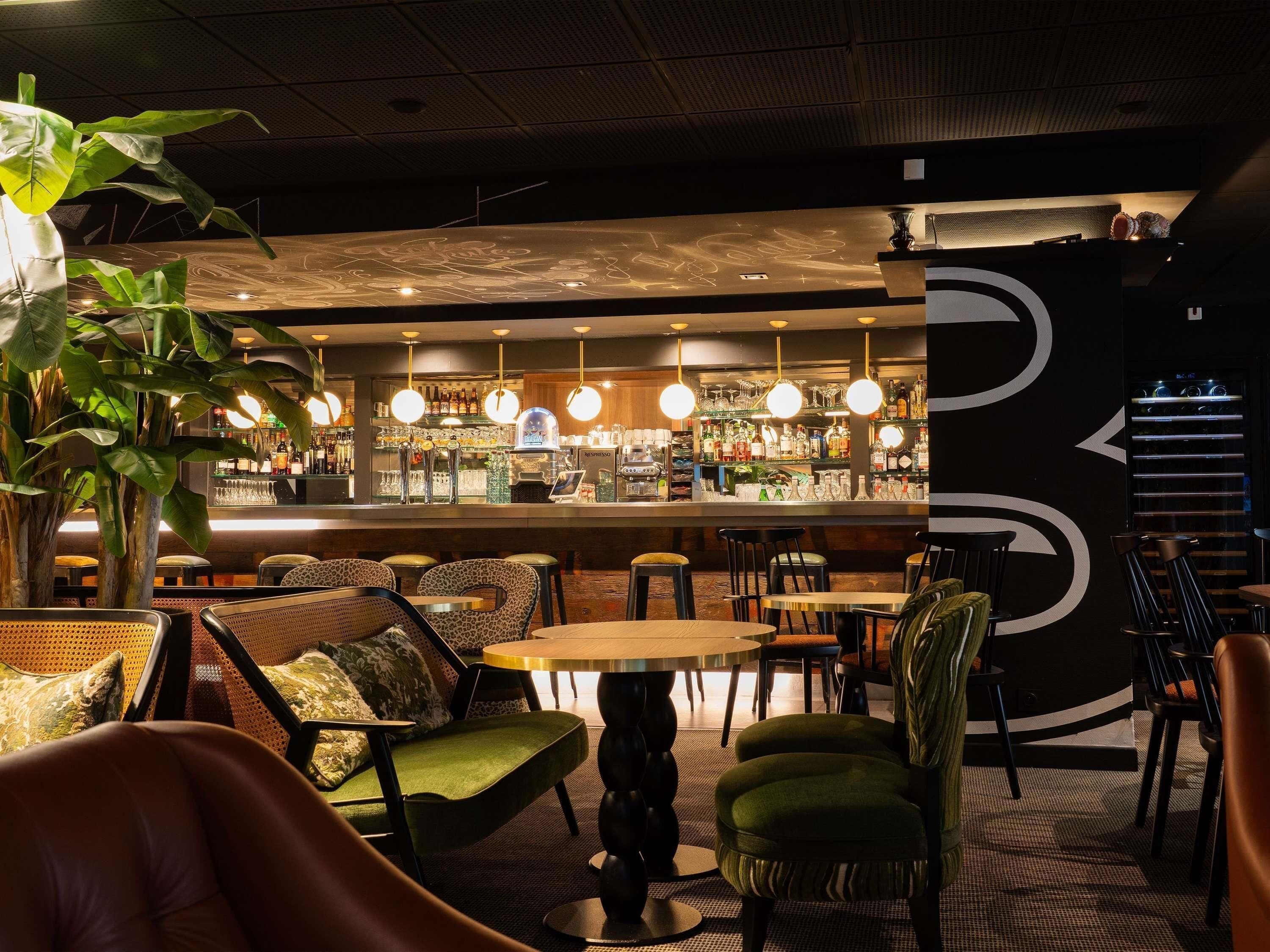 A bar area with seating, bar counter, and hanging lights.