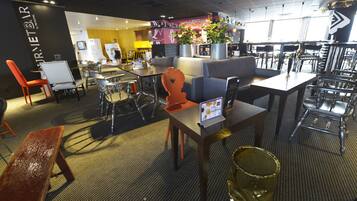 Restaurante moderno com área de bar, disposição de mesas e cardápio visível.