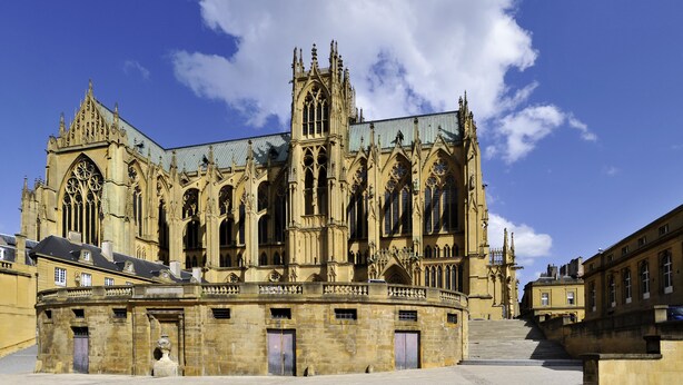Una catedral histórica con intrincada arquitectura gótica, amplios vitrales y una imponente torre del reloj.