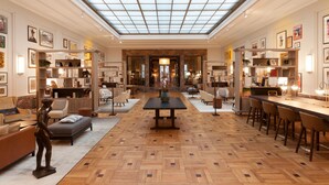 A spacious interior with a high ceiling, a central table, and seating areas. - Hotel Elephant Weimar, Autograph Collection (Weimar)