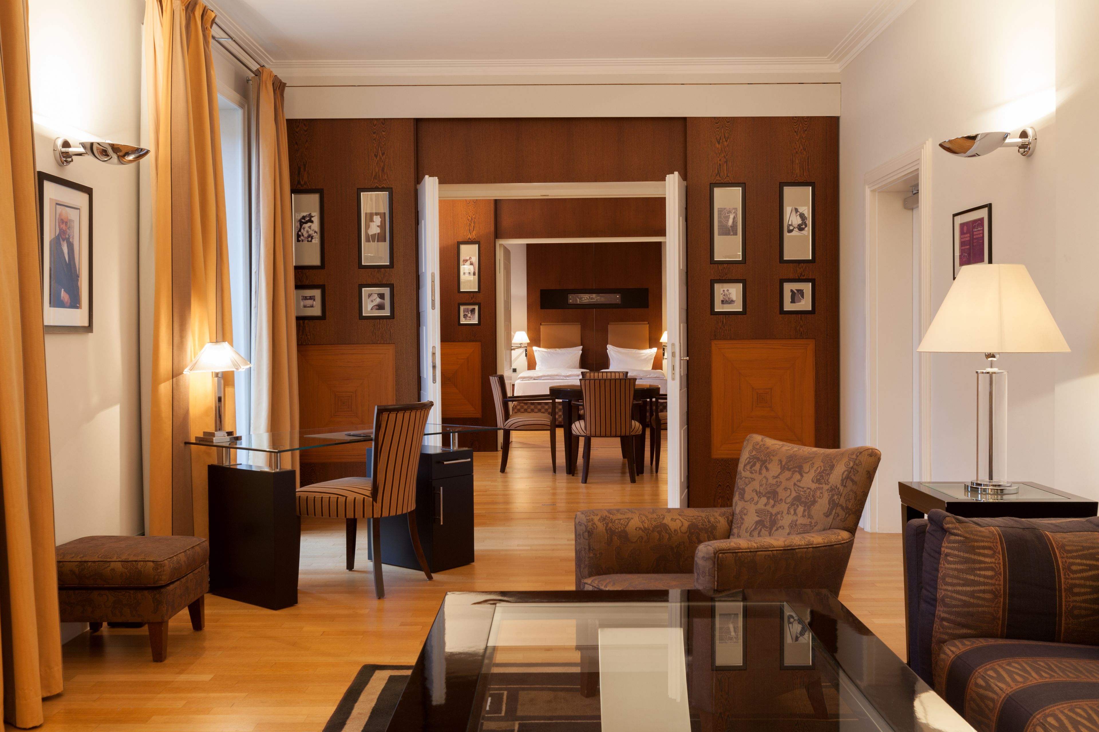Un hall de hotel con área de comedor, un sofá, una mesa de centro y una lámpara.