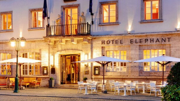 A hotel with a classic facade, outdoor seating with umbrellas, and a sign reading "HOTEL ELEPHANT". - Hotel Elephant Weimar, Autograph Collection (Weimar)