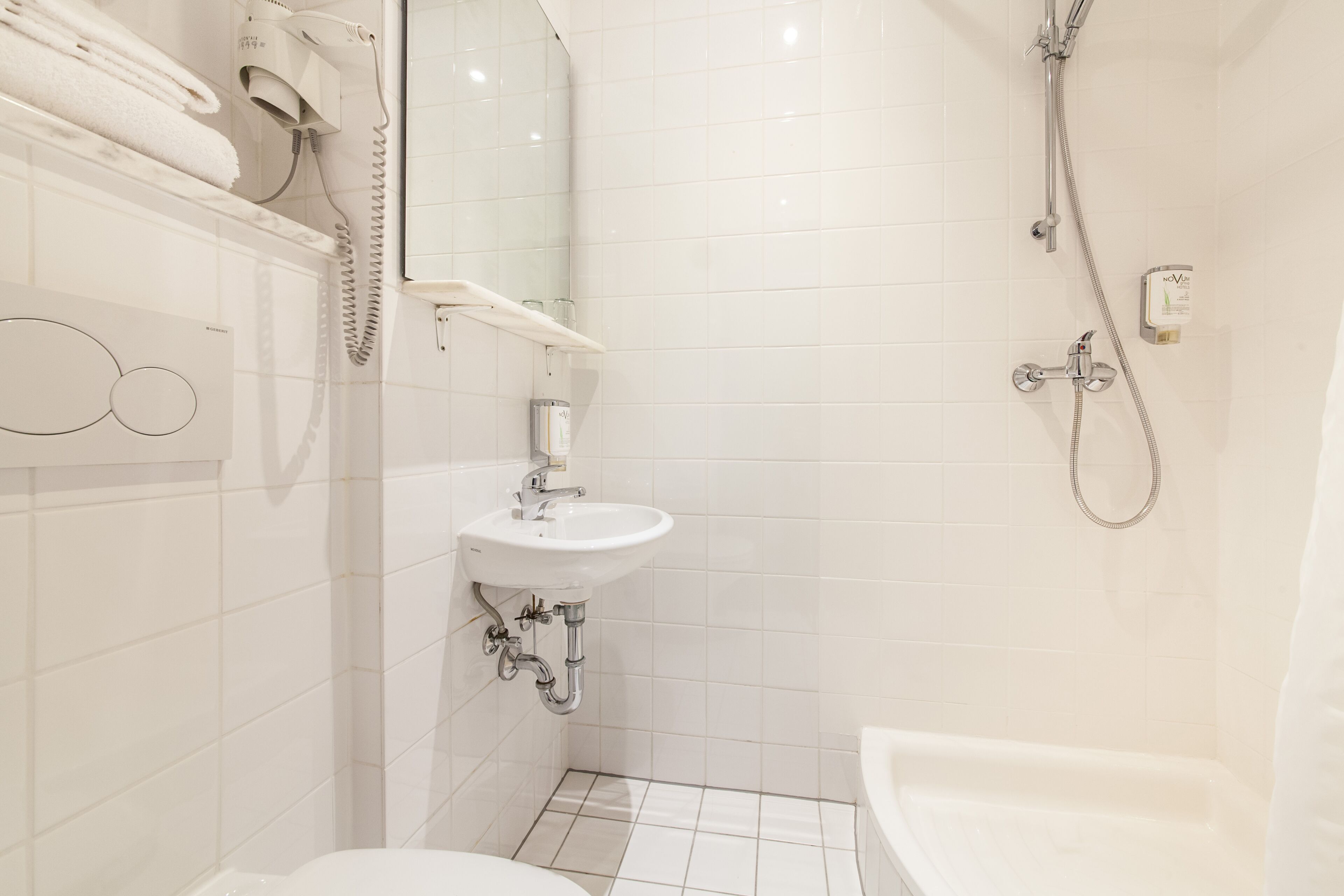 Ein modernes Badezimmer mit Waschbecken, Toilette und Badewanne.