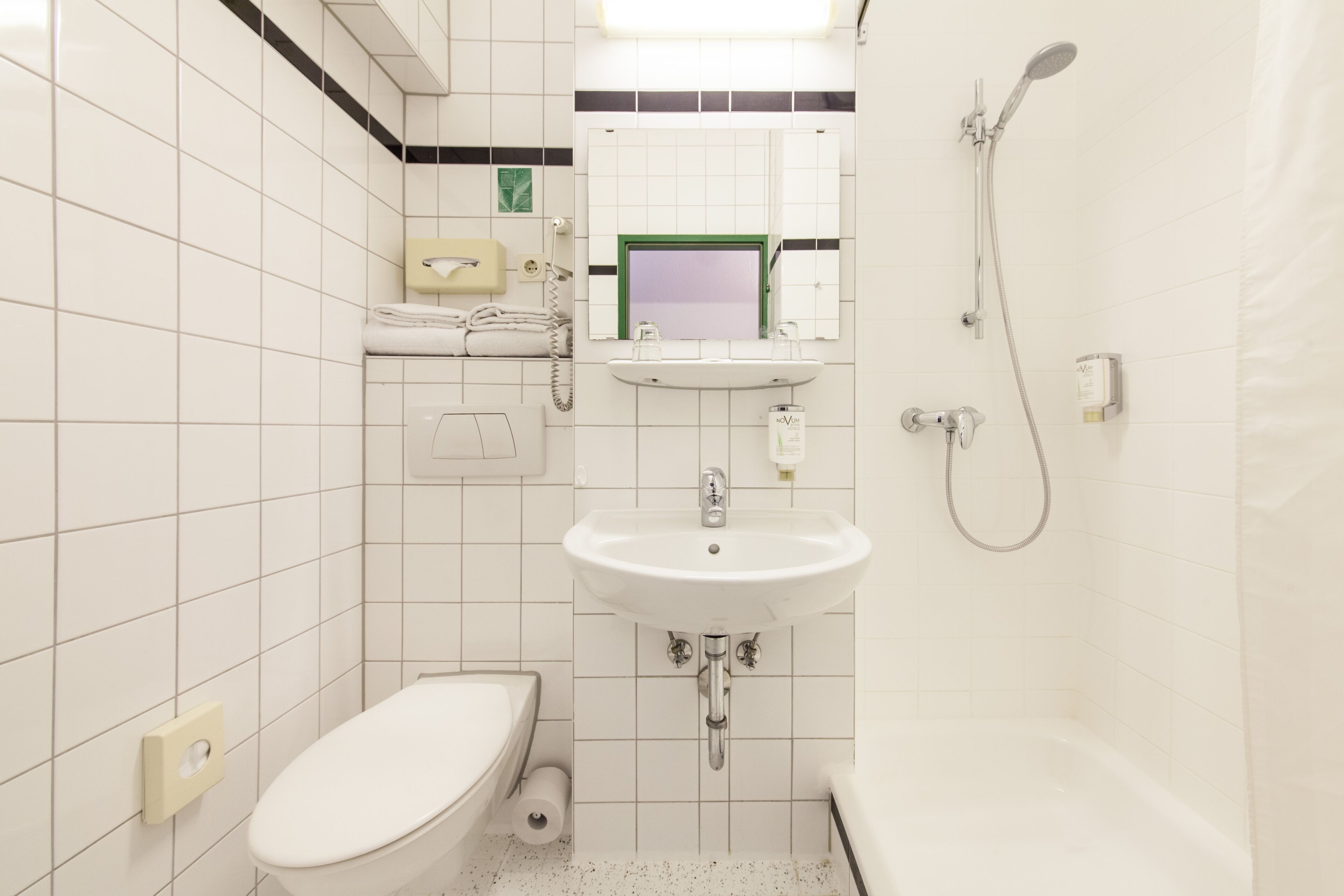 Un baño con inodoro, lavamanos y ducha.