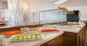 A buffet with various food items including sliced tomatoes, cucumbers, and carrots. - Sure Hotel by Best Western Muenchen Hauptbahnhof (Munich)