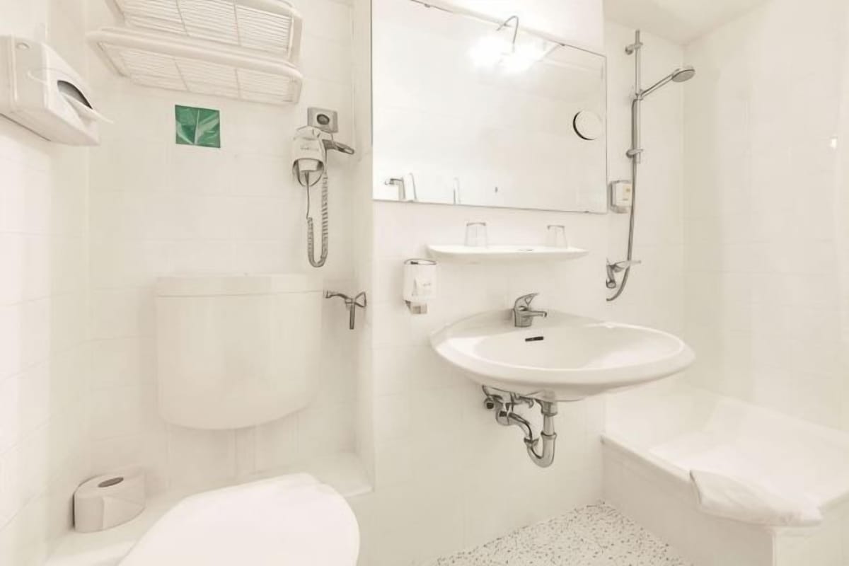 A bathroom with a toilet, sink, and shower.
