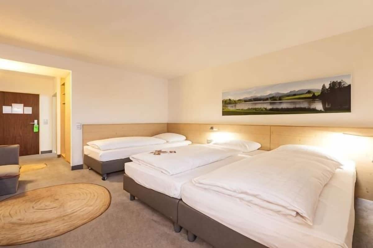 Una habitación de hotel con dos camas, un escritorio y una silla.