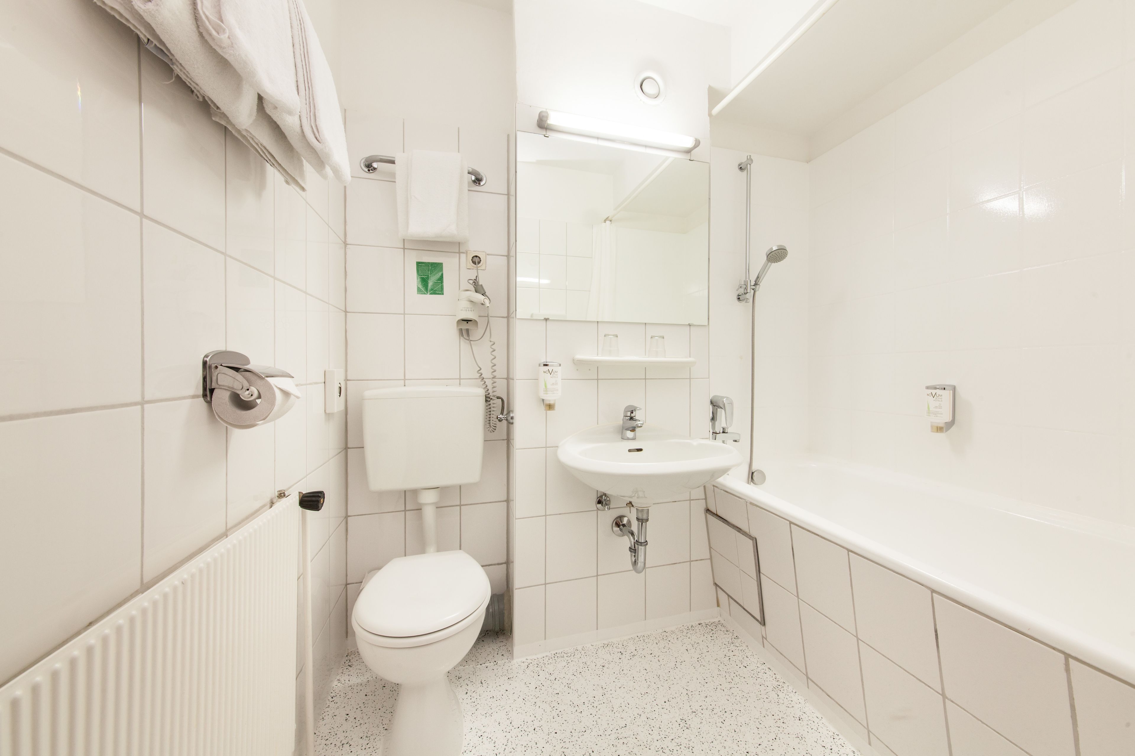A modern bathroom with a toilet, sink, and bathtub.
