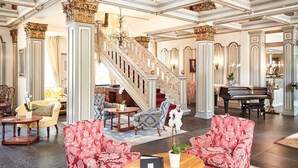 Un vaste hall d’entrée avec un escalier, des espaces de détente et un piano.