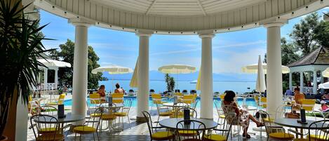 Una piscina cubierta, una piscina al aire libre, tumbonas