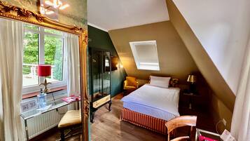 A bedroom with a bed, a desk, a chair, a window, and a skylight.