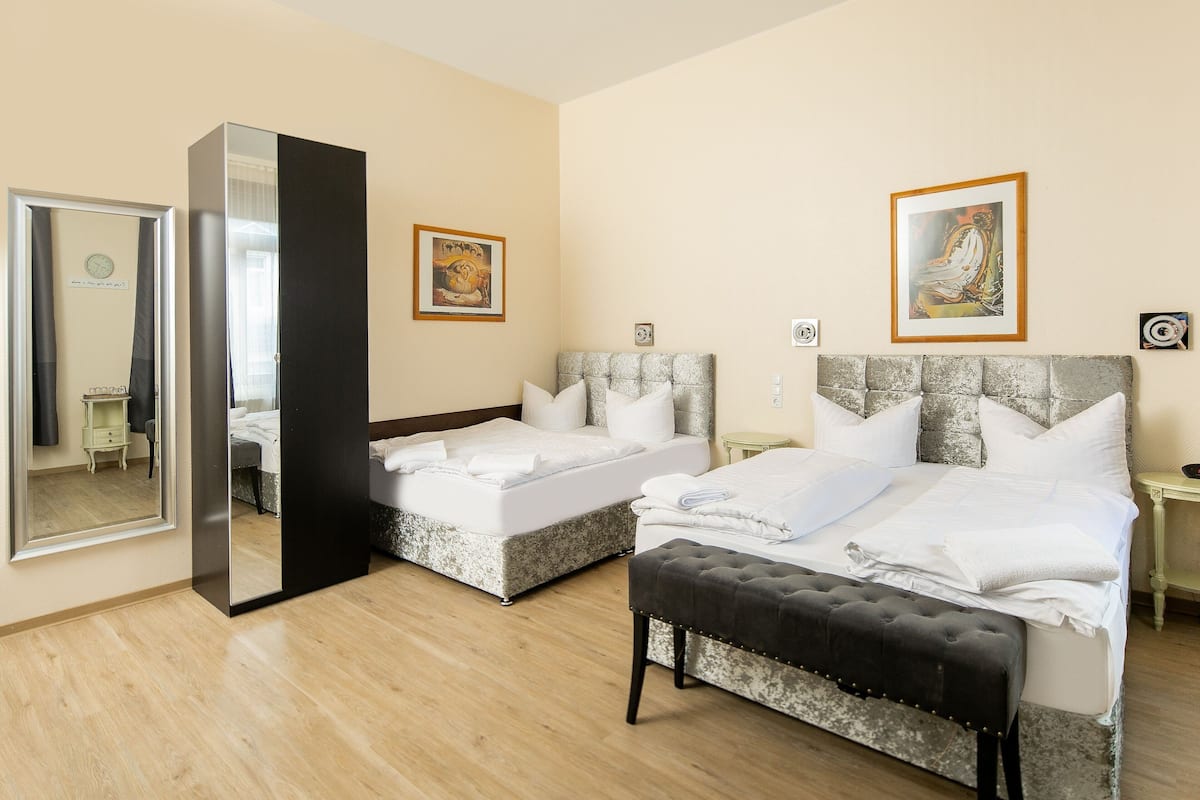 Ein Hotelzimmer mit zwei Betten, einem großen Spiegel und Bildern an den Wänden.