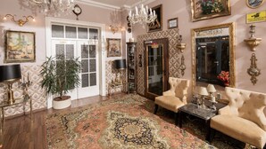 A spacious room with a large chandelier, a grand piano, and a large mirror. - City Hotel Kaiserhof (Offenbach am Main)
