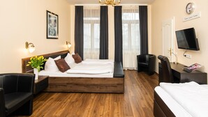 A hotel room with a wooden bed, a desk, a chair, a TV, and a window with curtains. - City Hotel Kaiserhof (Offenbach am Main)