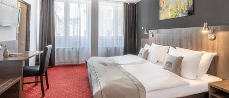 Ropa de cama hipoalergénica y caja de seguridad en la habitación