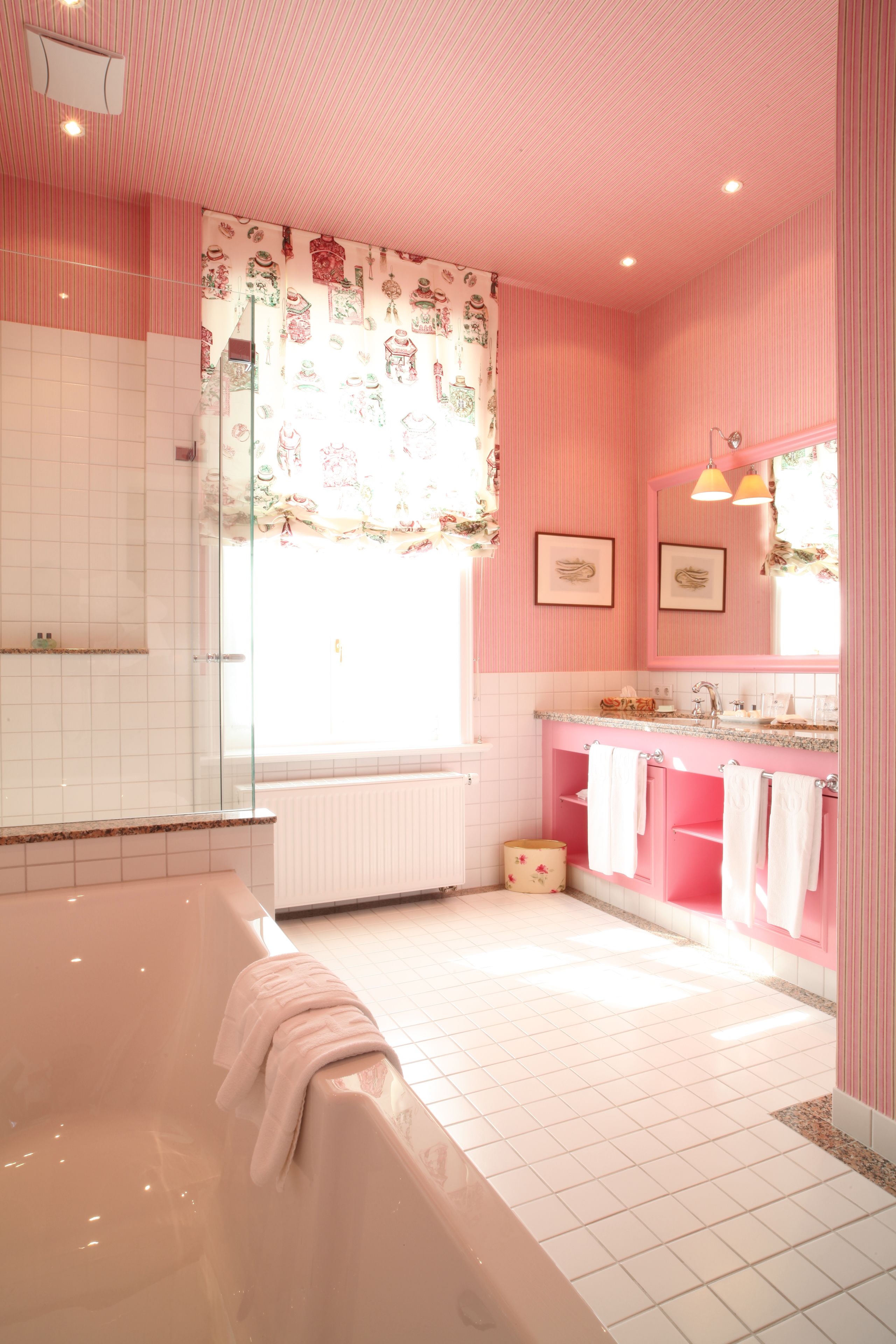 A bathroom with a bathtub, a shower, and a vanity with a mirror.