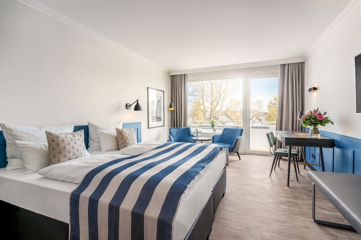 Une chambre d’hôtel avec un lit, un bureau et une chaise.