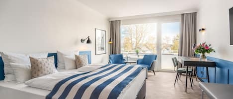 A hotel room with a bed, a desk, and a chair.