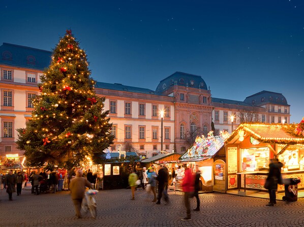 A large Christmas tree in front of a historic building with a market stall nearby. - Best Western Hotel Darmstadt Mitte (Darmstadt)