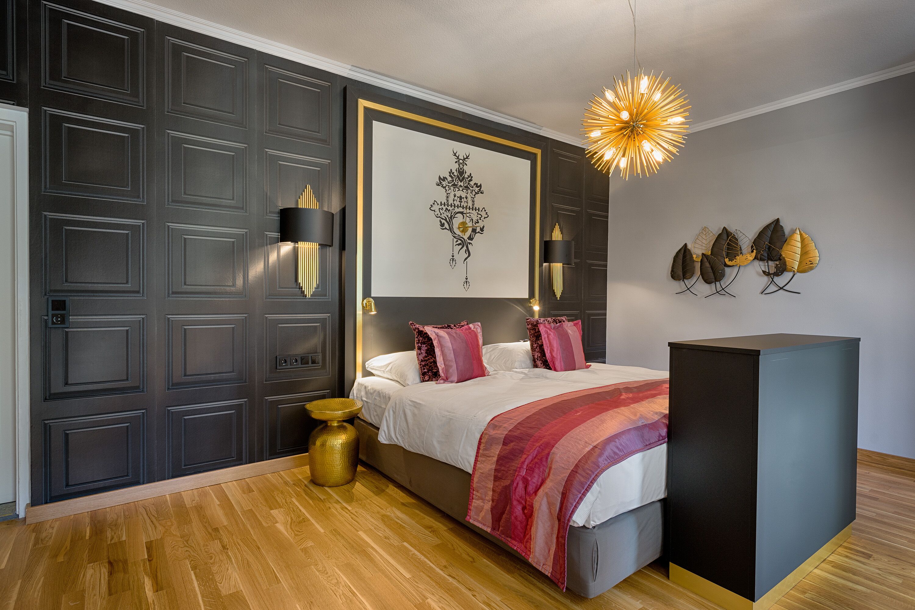 Quarto com cama, abajures, obra de arte na parede e um objeto decorativo.