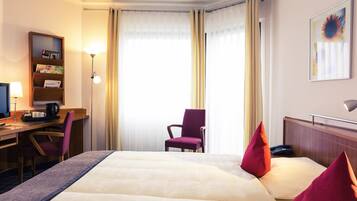 Ropa de cama hipoalergénica y caja de seguridad en la habitación