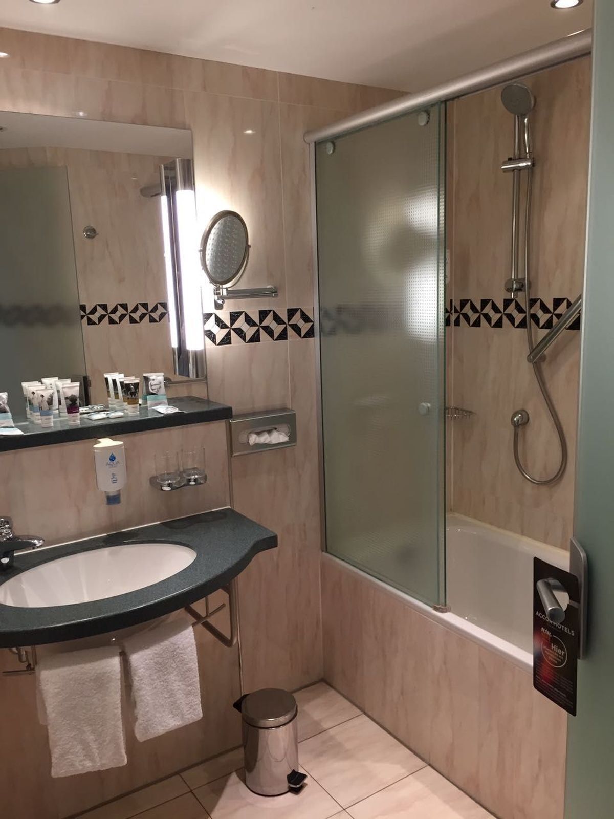 Un baño moderno con lavamanos, espejo y ducha.
