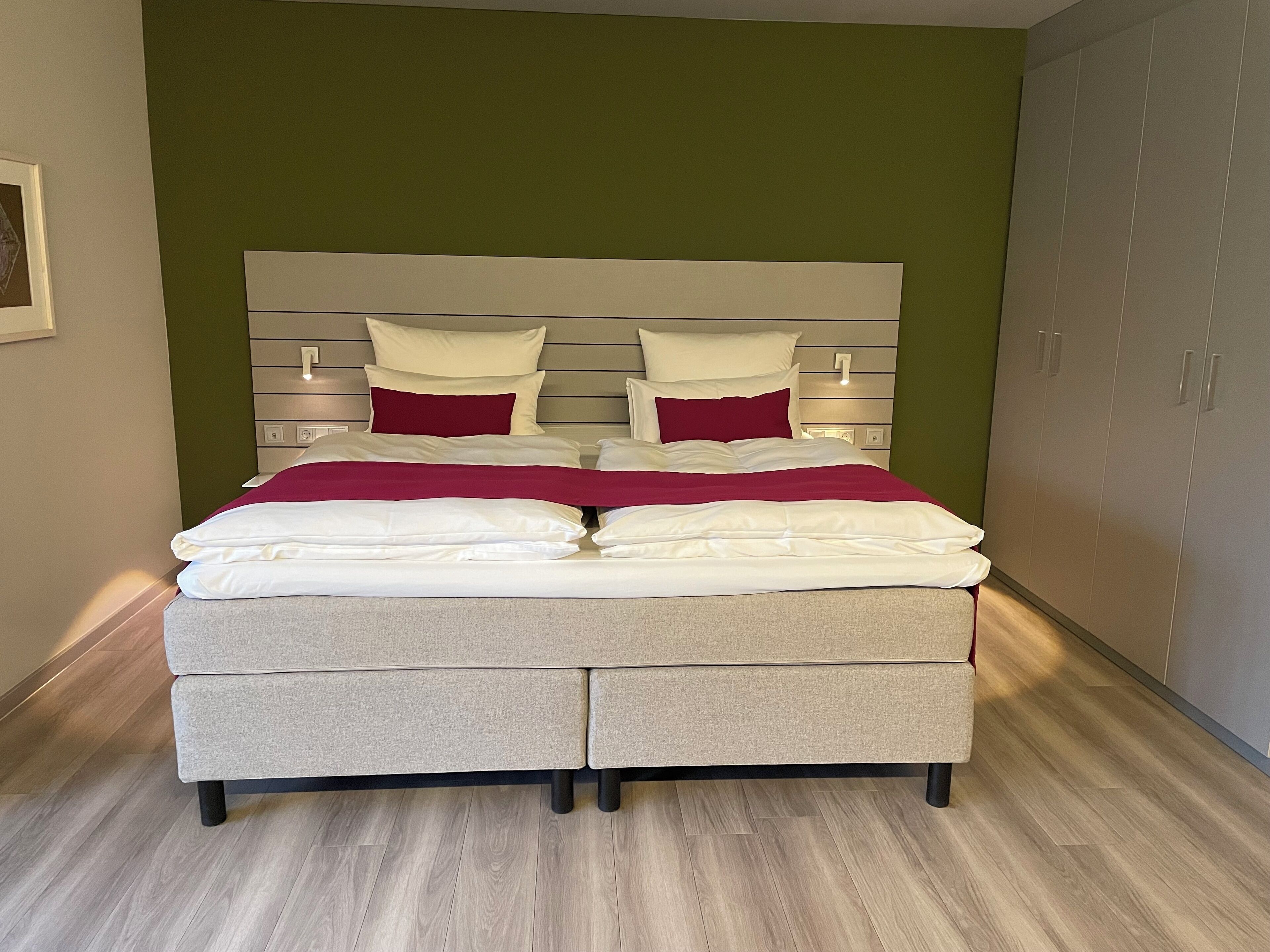 A bed with a headboard, two bedside tables, and a wardrobe.