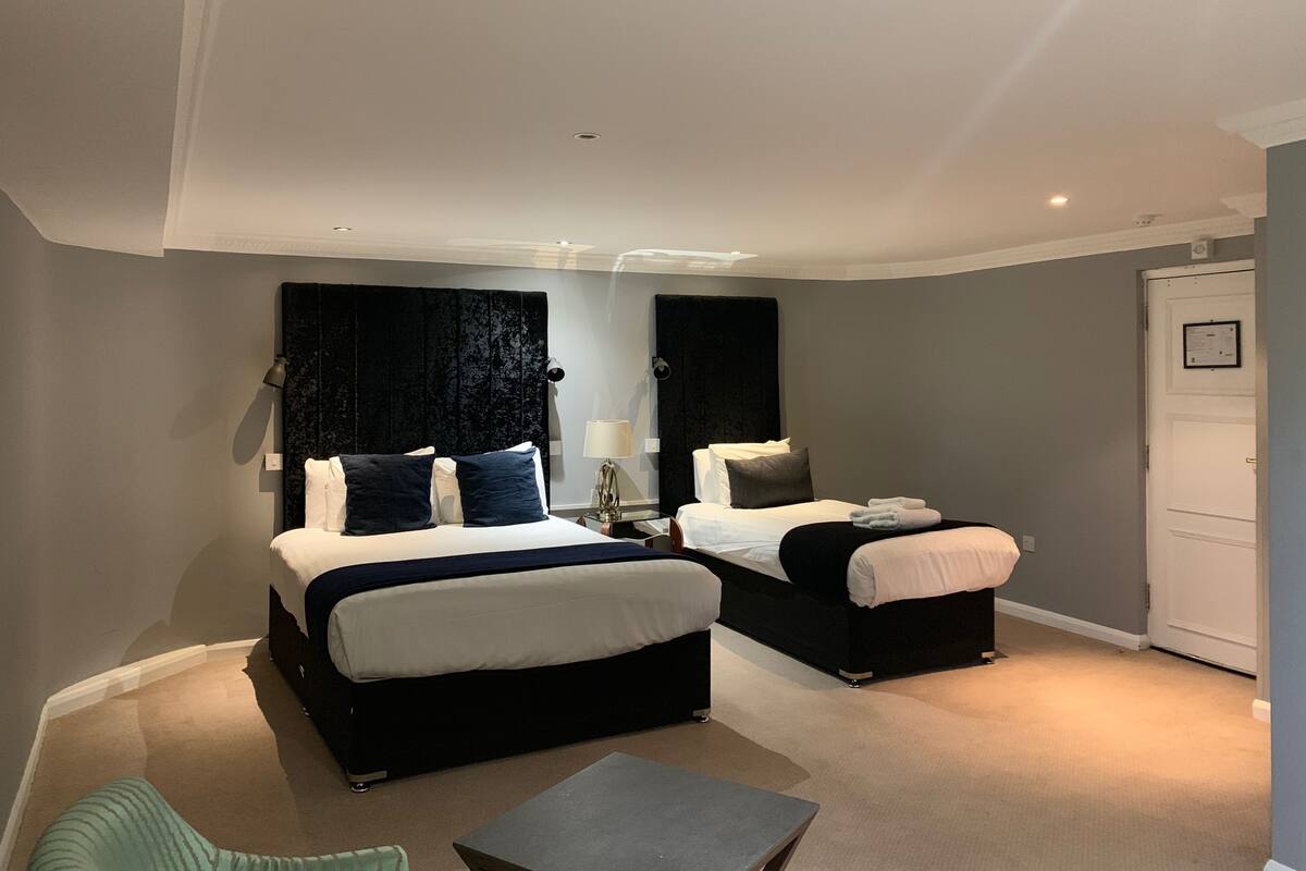 Ein Hotelzimmer mit zwei Betten, einem kleinen Tisch und einem Stuhl.