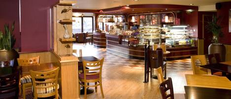 Un restaurante con muebles de madera, suelo a cuadros y una zona de bar.
