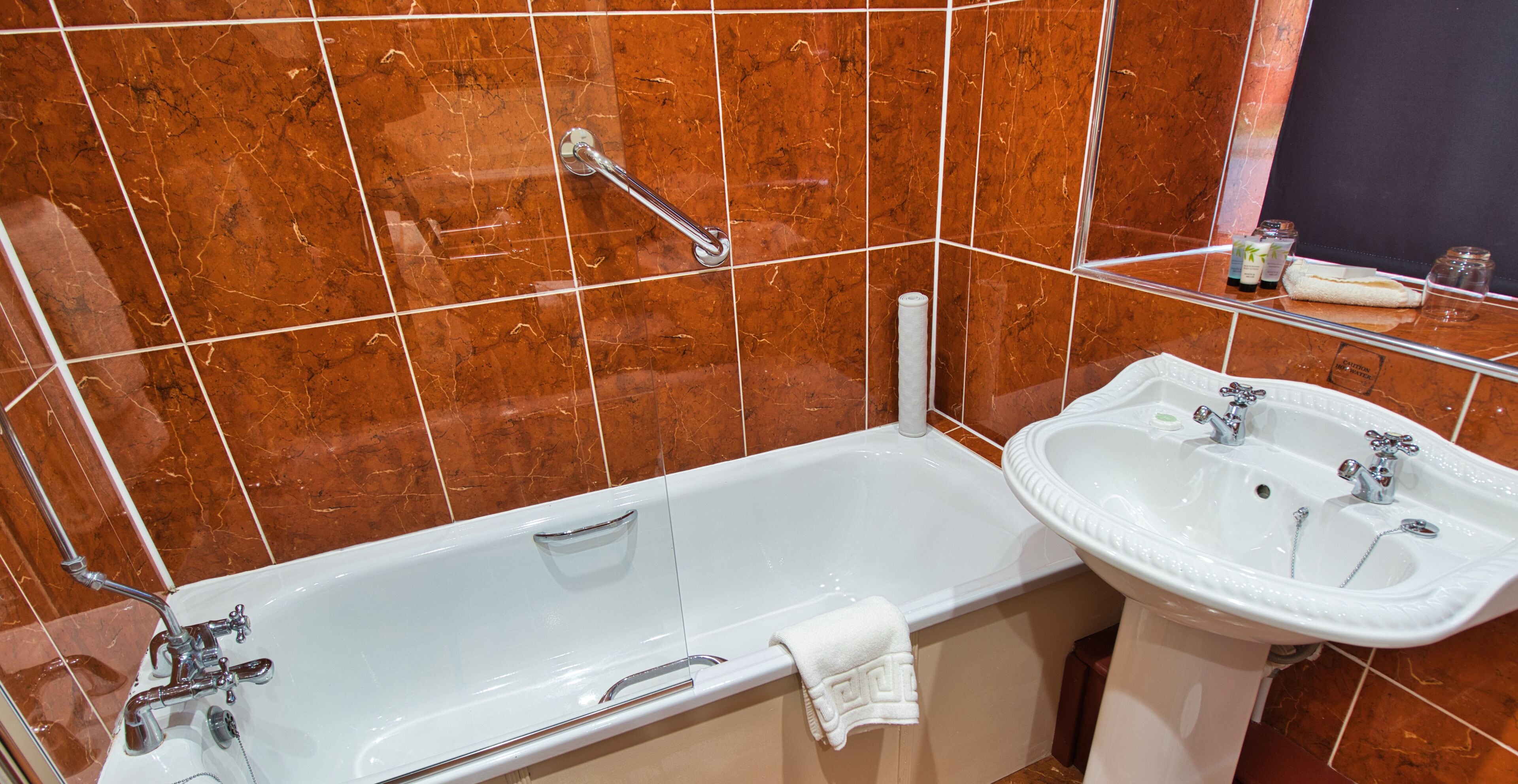 Ein Badezimmer mit Badewanne, Waschbecken und Spiegel.