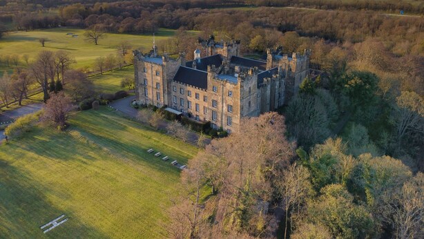 An aerial view of a castle surrounded by a lush green landscape with a clear sky. - Lumley Castle Hotel (Chester-le-Street)