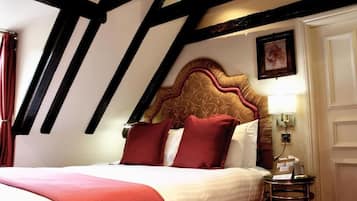 Una habitación de hotel con una cama, una mesita de noche, una lámpara y un cuadro en la pared.