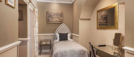 A bedroom with a bed, a desk, a chair, a mirror, and a painting on the wall.