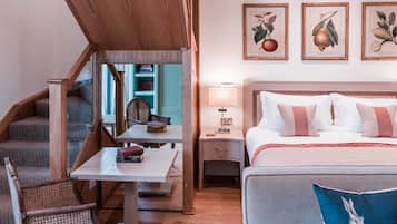 A hotel room with a bed, a desk, a chair, and a staircase.