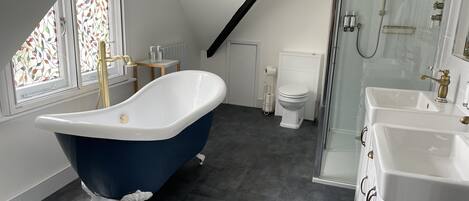 Un baño moderno con una bañera independiente, ducha y váter.