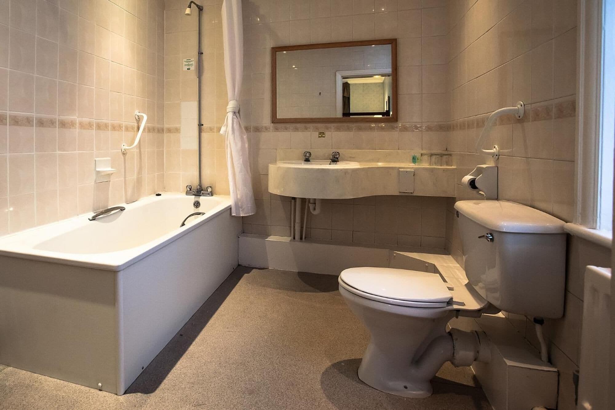 Un baño con bañera, lavabo e inodoro.