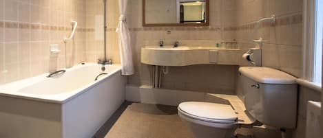 Un baño con bañera, lavabo e inodoro.