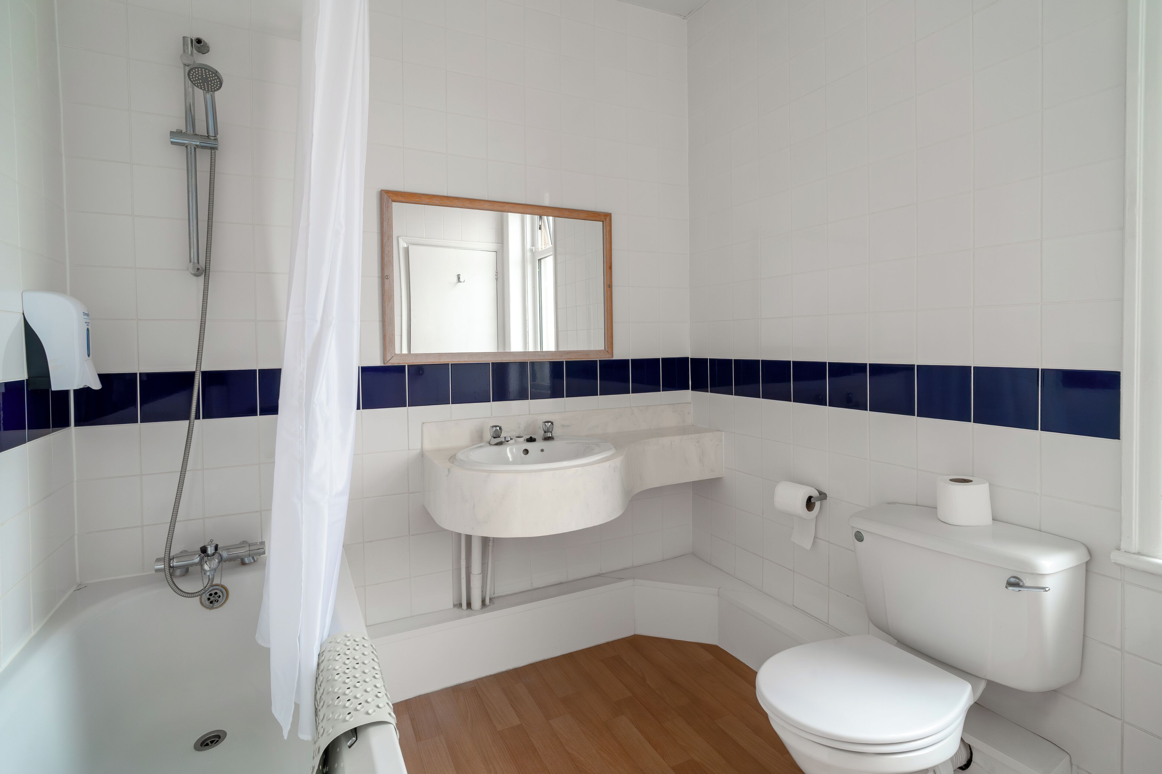 A bathroom with a bathtub, a sink, a toilet, and a shower.
