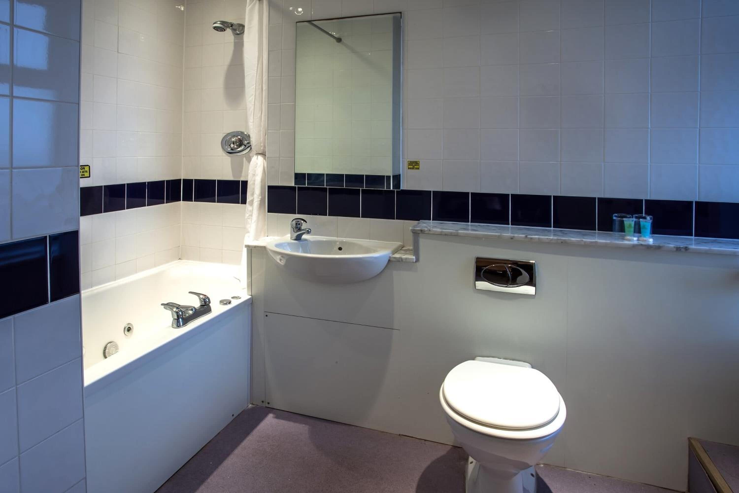 Un baño con bañera, lavamanos e inodoro.