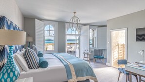 Un dormitorio con una cama, un escritorio y una silla. Hay ventanas y vistas al exterior.