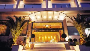 Um hotel com vários andares, uma entrada destacada, janelas amplas e uma placa com o nome 'Zafolia'.