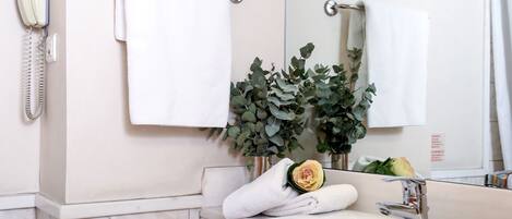 A bathroom with a white sink, a mirror, a towel rack, and a telephone.